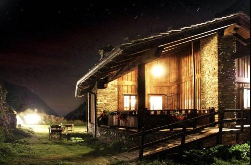 a log cabin at night with lights at La Rêverie de Thumel - Suite in Rhêmes-Notre-Dame
