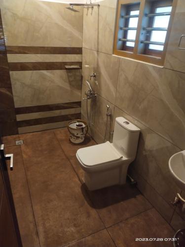 a bathroom with a toilet and a sink at Merlys Fruit Garden - Resort at Thattekkad in Kotamangalam