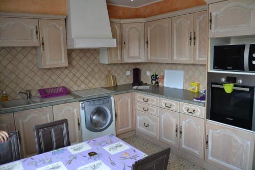 a kitchen with white cabinets and a washing machine at City Break in Narbonne