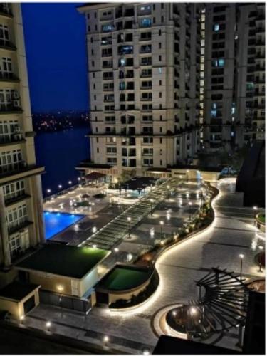 a view of a building with a pool at night at Cozzzy hut @ Riverine Diamond Kuching in Kuching