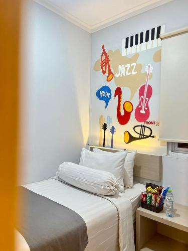 Bett in einem Zimmer mit einer Wand mit Musikzeichen in der Unterkunft Front One Cabin Sunter in Jakarta