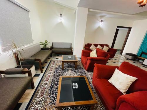 a living room with red couches and a table at Gautam Hotel in Varanasi