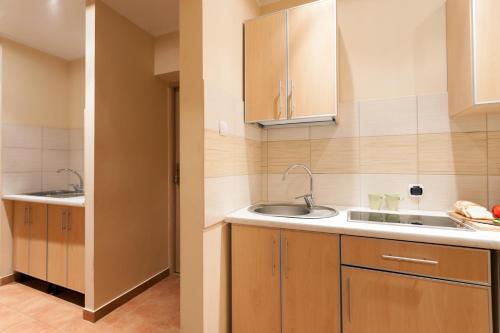 a kitchen with wooden cabinets and a sink at Dom noclegowy „POD MNICHEM” in Wambierzyce