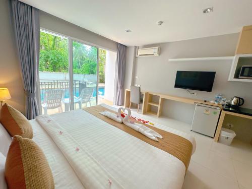 een hotelkamer met een groot bed en een televisie bij Ahad Suite Ao Nang By Ma in Ao Nang Beach