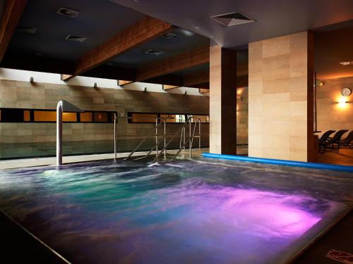 - une piscine dans une pièce d'eau bleue et violette dans l'établissement VacationClub - Arka Apartament 330, à Kołobrzeg