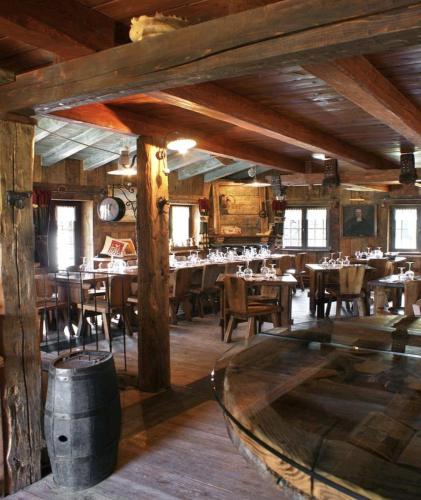 a restaurant with wooden tables and chairs in a room at La Rêverie de Thumel - Suite in Rhêmes-Notre-Dame