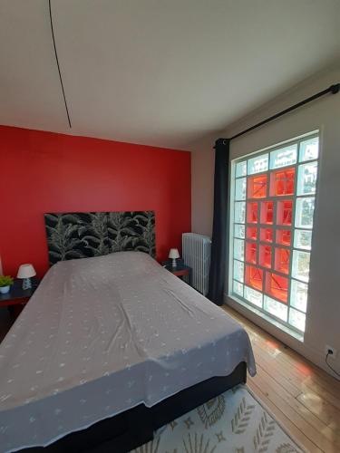 um quarto com uma cama e uma grande janela em Chambre d'hôte près de Paris em Épinay-sur-Seine