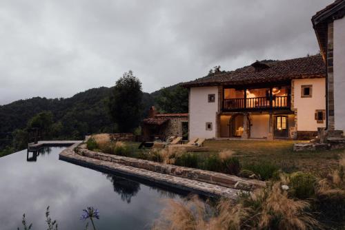 a house next to a body of water at SOLO PALACIO - Boutique Hotel & Spa in Llanuces