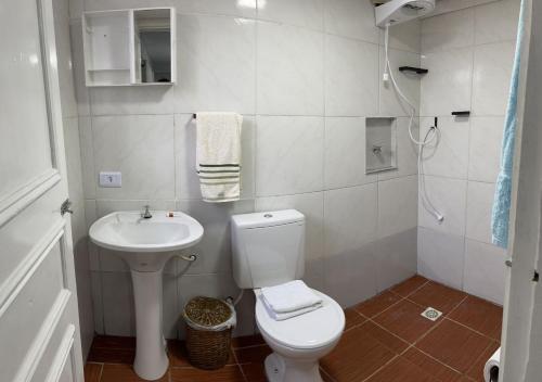 a small bathroom with a toilet and a sink at Dith's House (kitnet 1) in Campos do Jordão