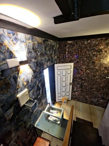 a room with a stone wall with a door at Rock Lake Villa in Vagamon