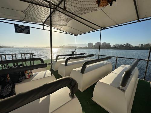 a boat with four seats on the water at Flat com Vista Panorâmica -15- na Barra da Tijuca - Estacionamento Gratuito - Frigobar - Ar condicionado - Piscina - Academia - Balsa para Praia Grátis - Varanda - Vista Parcial Mar e Lagoa in Barra da Tijuca
