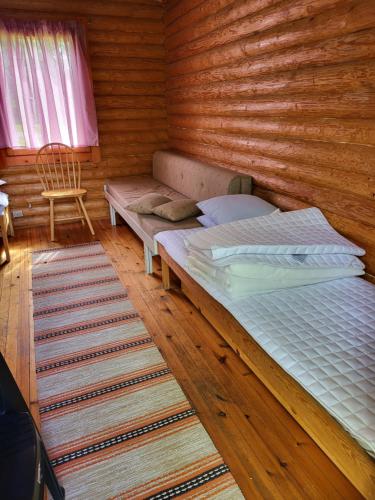 1 dormitorio con 1 cama y 1 silla en una habitación en Pahkalanniemi Camping en Parkano