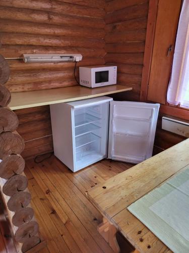 una pequeña cocina con microondas y nevera. en Pahkalanniemi Camping en Parkano