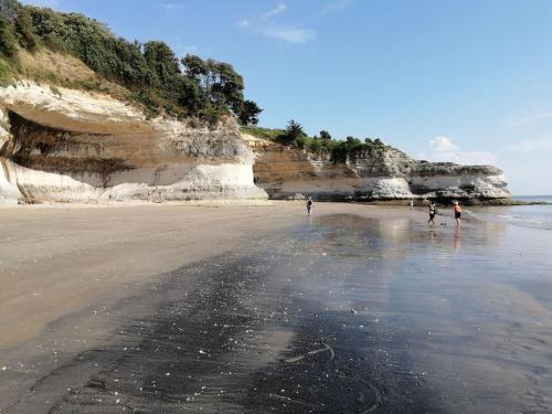 een groep mensen die op het strand lopen bij logis Paul Massy in Meschers-sur-Gironde