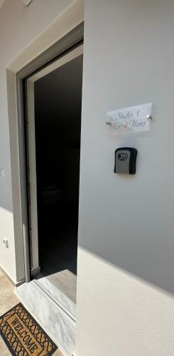 a door to a room with a clock on the wall at Harihara Guesthouse near Airport in Paianía
