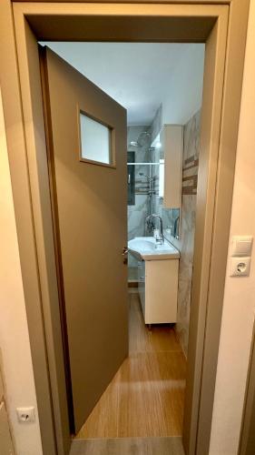 a door leading into a bathroom with a sink at Harihara Guesthouse near Airport in Paianía