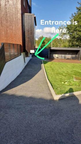 a green arrow pointing to an entrance to a building at Near Bergen City, Apartment 7 min from the airport, free parking in Bergen