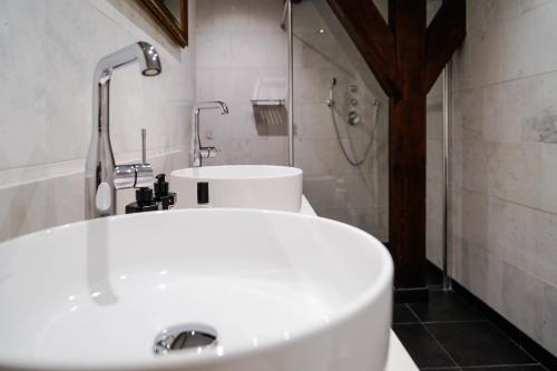 a bathroom with a white sink and a shower at Central Park Voorburg - Relais & Chateaux in Voorburg