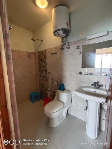 a bathroom with a toilet and a sink at Hotel Hidden House (Fair View) in Pelling