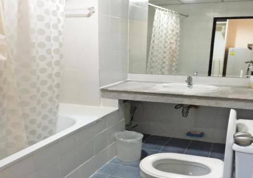 a bathroom with a sink and a toilet and a bath tub at Jomtien Longstay Hotel - SHA Plus Certified in Jomtien Beach