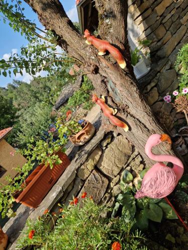two fake flamingos sitting on the side of a tree at Къщи за гости "Зелената долина" in Dalbok-Dol