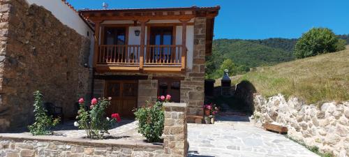 a stone house with a balcony on a hill at Casa Rural Pembes in Pembes