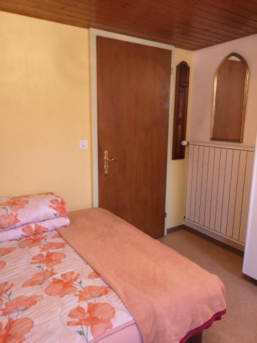 a bedroom with a bed and a wooden door at Ferienzimmer Appenzell in Appenzell