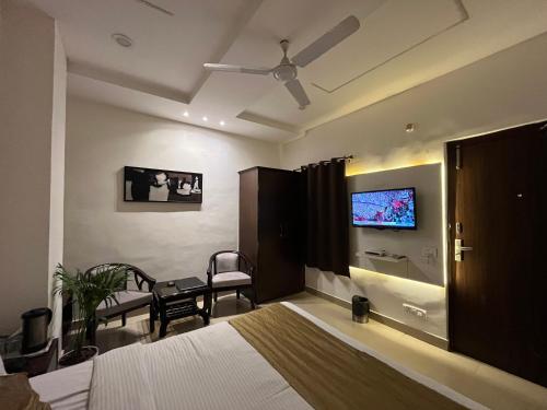 a bedroom with a bed and a tv on the wall at Hotel The Benz in Chandīgarh