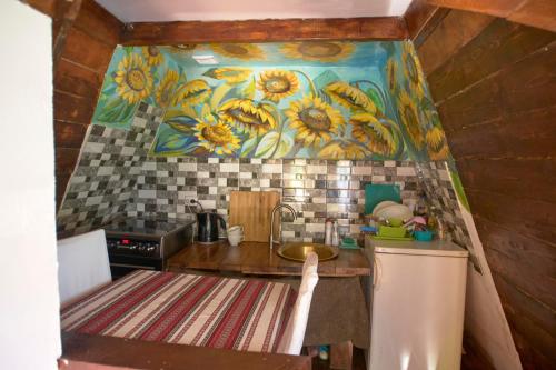 una cocina con un mural de girasoles en la pared en Baba Yagas house, en Rakhiv