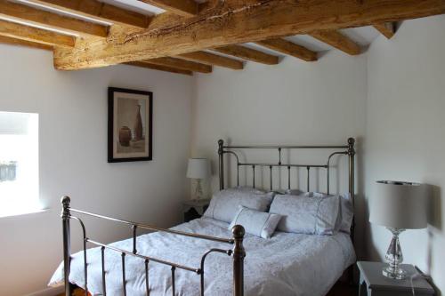 1 dormitorio con cama y techo de madera en Deepmoor Farmhouse, Doveridge, Derbys., en Doveridge