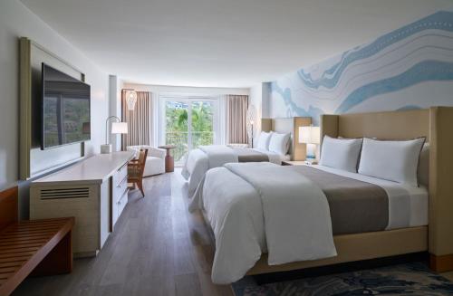 um quarto de hotel com duas camas e uma secretária em The Westin Beach Resort & Spa at Frenchman's Reef em Frydendal