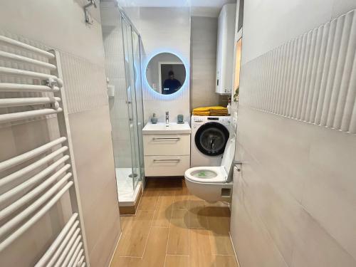 une salle de bain avec toilettes et lavabo et une machine à laver dans l'établissement Appartement coup de coeur Montparnasse, à Paris