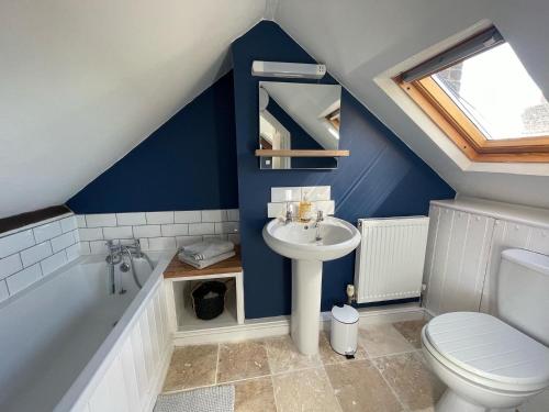 a bathroom with a sink and a toilet and a tub at Stylish 2 bedroom apartment close to beaches in Fakenham