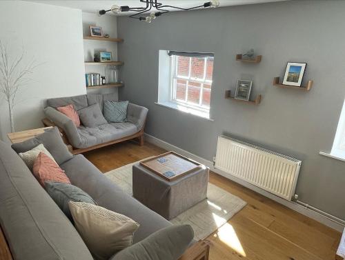 a living room with a couch and a table at Stylish 2 bedroom apartment close to beaches in Fakenham