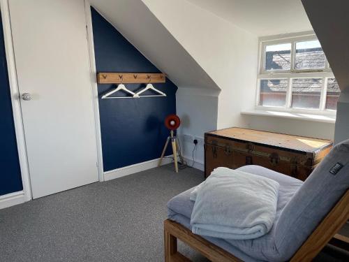 a bedroom with a bed and a blue wall at Stylish 2 bedroom apartment close to beaches in Fakenham
