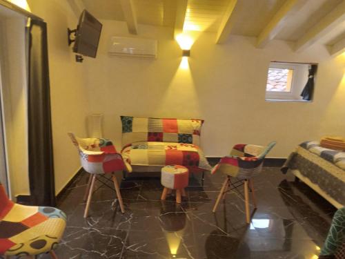 a room with chairs and a table and a bed at Anteros Luxury Suite in Montalbano Elicona