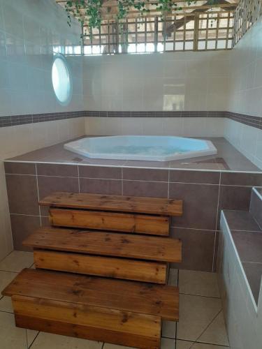 La salle de bains est pourvue d'un jacuzzi et d'un escalier en bois. dans l'établissement Appartement village de vacances, à Parentis-en-Born
