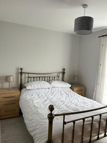 1 dormitorio con 1 cama blanca y 2 mesitas de noche en Garden Avenue, en Portstewart