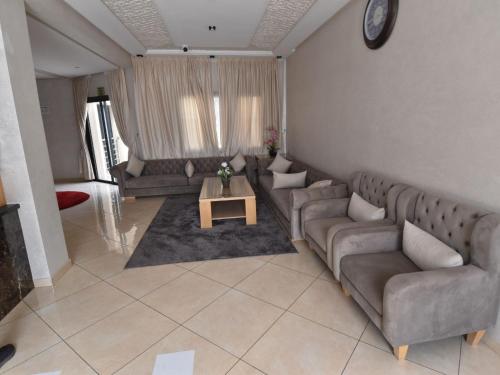 a living room with couches and a table at Perle de Souihla in Oulad Sidi Cheïkh