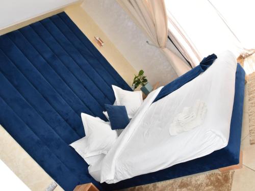 a blue and white bed with white pillows at Perle de Souihla in Oulad Sidi Cheïkh