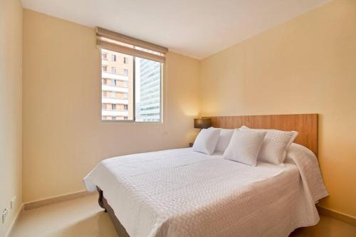 a bedroom with a white bed with a window at studio 14 in Medellín