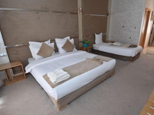 a bedroom with two beds with towels on them at Perle de Souihla in Oulad Sidi Cheïkh