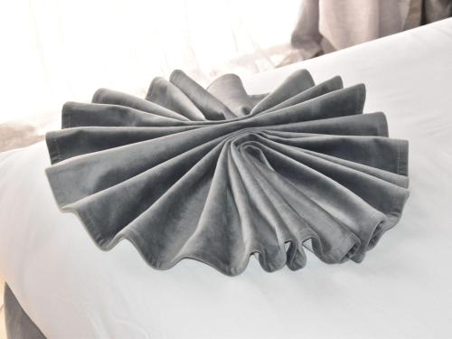 a black cloth bow on top of a white bed at Perle de Souihla in Oulad Sidi Cheïkh