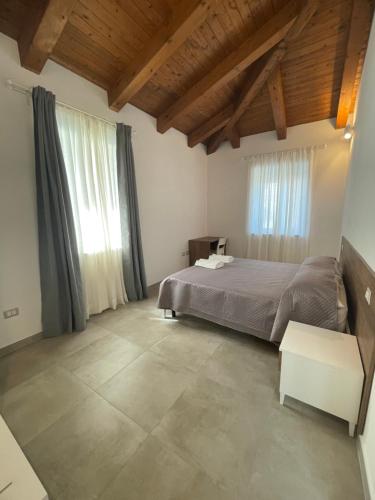 1 dormitorio con cama y ventana grande en Tenuta La Torre en Tropea