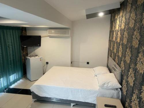 a bedroom with a white bed and a tv at Africa in the heart of city center in Antalya