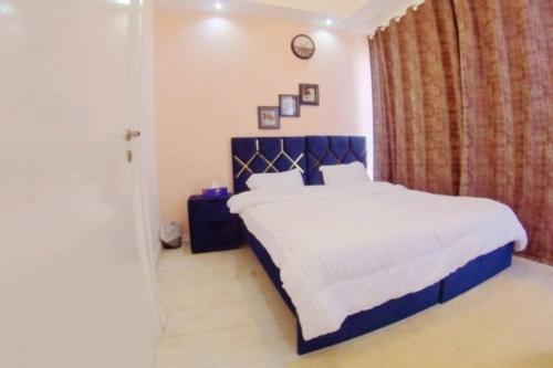 a bedroom with a large bed with a blue headboard at Romantic Hideaway, 1-BHK Villa in Dubai