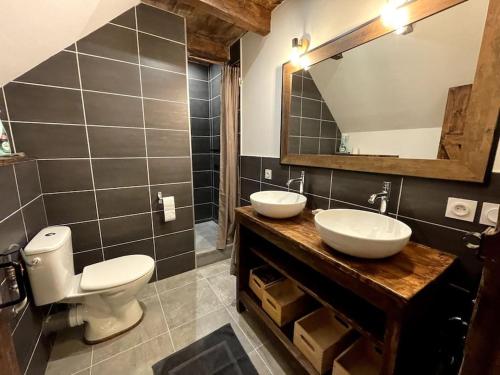 ein Badezimmer mit zwei Waschbecken, einem WC und einem Spiegel in der Unterkunft Gîte du Pays-de-Salers, Cantal, classé 1* in Saint-Projet-de-Salers