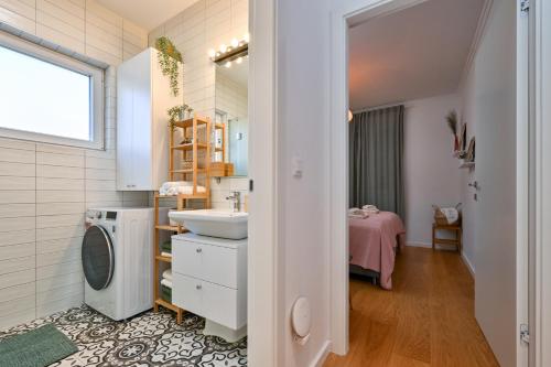 a bathroom with a sink and a washing machine at Apartment Zicer in Zagreb
