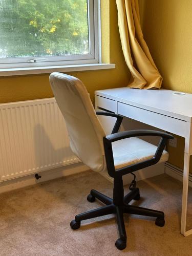 a white desk and a chair next to a window at Double Room Rent in Birmingham