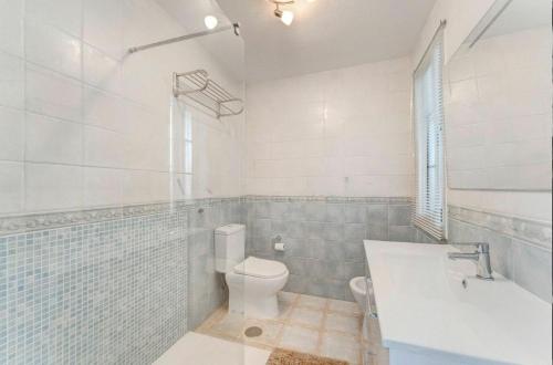 a bathroom with a toilet and a tub and a sink at Sunny Garden 1 BR Apartment Arona in Playa de las Americas